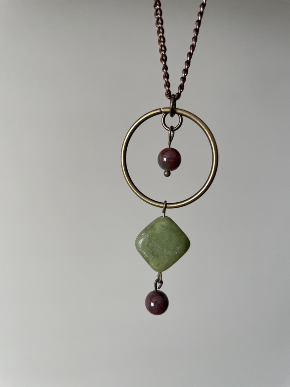 Brass hoop red brown round gemstone necklace.